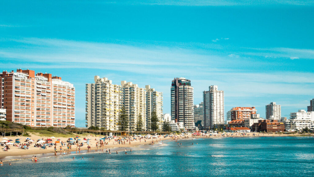 Praia de Punta del Este, com prédios e alguns dos melhores hotéis em Punta del Este ao fundo, margeando a orla.